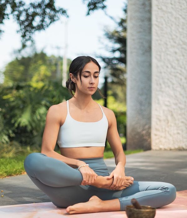 Serene person meditating outdoors in a peaceful natural setting.